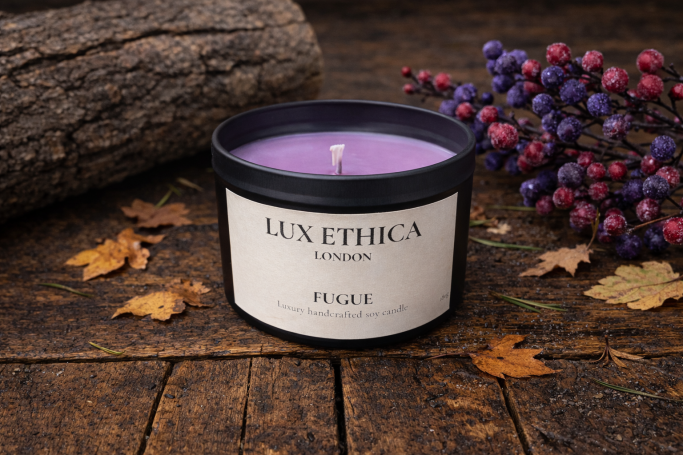 Purple candle with autumnal leaves and berries